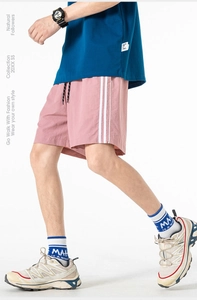 Dettaglio dei pantaloncini sportivi rosa con strisce bianche e coulisse nera regolabile