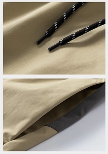 Detail of khaki cargo shorts showing black polka dot drawstring and grey pocket trim