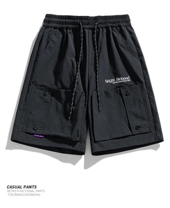 Detailed view of elastic waistband and functional cargo pockets on black casual shorts
