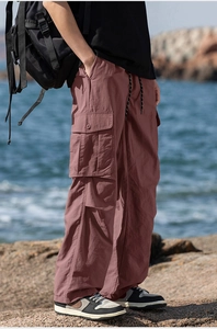 Detail view of pink cargo pants with large side flap pockets and drawstring waist