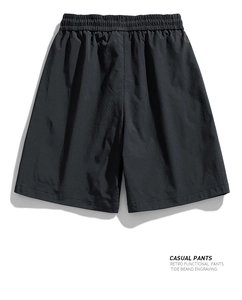 Detail view of water-resistant black cargo shorts with elastic waist and retro functional fabric