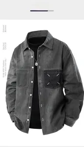 Detailed close-up of dark grey denim shirt jacket with white cross stitch on pocket