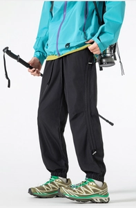 Detail view of black hiking pants with elastic cuffs and functional side zippers