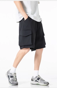Détail d'un short cargo noir avec de grandes poches à rabat et taille à cordon pour homme