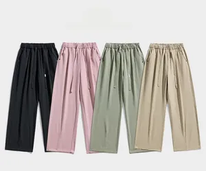 Detail view of adjustable drawstring waistbands and soft pleats on casual wide-leg pants
