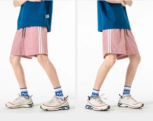 Dettaglio di pantaloncini sportivi rosa con strisce laterali e coulisse nera regolabile