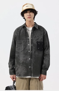 Close-up of washed gray denim shirt with contrast white stitching and pocket detail