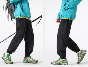 Detailed close-up of outdoor hiking pants featuring functional side zipper pockets and cuffs