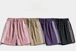 Dettaglio di quattro pantaloncini sportivi colorati con vita elastica e strisce
