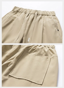 Detail of khaki hiking pants showing elastic drawstring waist and reinforced pocket stitching