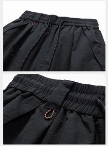 Close-up of lightweight quick-dry cargo shorts featuring elastic waistband and functional buckle