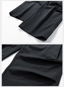 Detail view of lightweight black outdoor pants with precision stitching and fabric texture