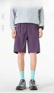 Detail of dark purple quick-dry nylon shorts with elastic waistband and outdoor utility style