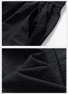 Detail of black tactical pants showing elastic waistband and quick-dry nylon fabric texture