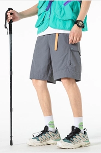 Detail of dark grey cargo shorts featuring side flap pockets and orange contrast waist tape