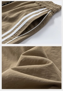 Dettaglio dei pantaloncini sportivi kaki con vita elastica, coulisse e tasca a righe