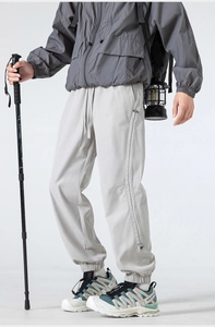 Detail of light gray outdoor tactical pants featuring ripstop fabric and gorpcore style