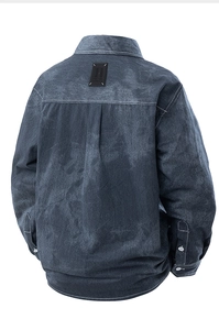 Detail view of the back of a washed denim shirt featuring back yoke and brand label