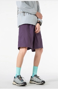 Detail of purple quick-dry shorts featuring cargo side pockets and adjustable drawstring waist