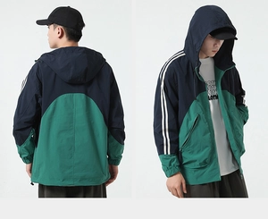 Dettaglio della giacca con cappuccio color-block in blu navy e verde e strisce
