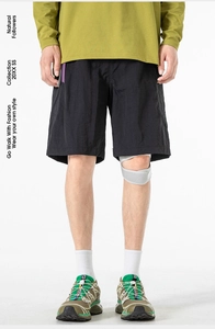 Detail of men's black tactical cargo shorts featuring water-resistant fabric and loose fit
