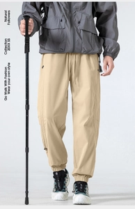 Detail of khaki outdoor cargo pants featuring elastic drawstring waist and functional pockets