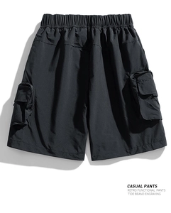 Detail of black waterproof cargo shorts with elastic waistband and embroidered utility pocket