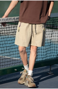 Close-up of khaki cargo shorts with elastic drawstring waist and colorful zippers