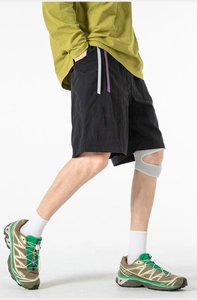 Detail of black technical fabric shorts with grey and purple contrast webbing belt