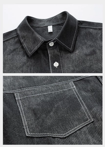 Detail view of dark grey denim shirt showing white contrast stitching and chest pocket