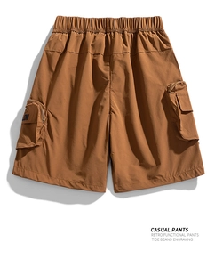 Close-up of caramel cargo shorts with elastic waist, large flap pockets and zipper details