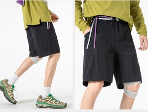 Detail of black technical shorts featuring a contrasting adjustable two-tone waist belt