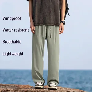 Outdoor shot of men's lightweight hiking pants with water-repellent fabric on coast rocks
