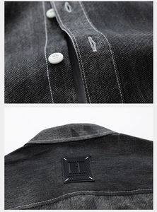 Detail of dark grey denim shirt with contrast white stitching and resin buttons