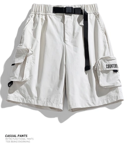 Detail of adjustable buckle belt and large cargo pocket on functional cream shorts