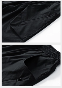 Detail of black shorts showing elastic waistband, zipper pocket, and high-quality fabric