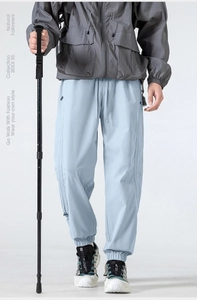 Detailed view of light blue outdoor hiking pants featuring elastic waist and zip pockets