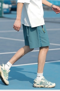Detail of teal quick-dry athletic shorts with side stripe and contrast zipper cord