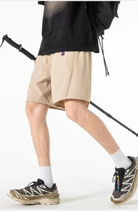 Detail view of khaki quick-dry cargo shorts with purple accent tag for outdoor hiking