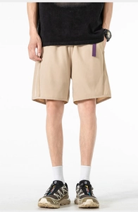 Detail of khaki tech shorts with a distinctive purple belt and quick-dry fabric texture