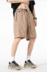 Detail shot of khaki tech shorts with a woven belt in casual outdoor cargo style