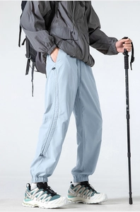 Detail of light blue outdoor functional pants with cargo pocket and elastic ankle cuffs