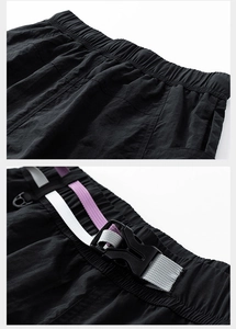 Detail of elastic waistband and tactical buckle on black nylon moisture-wicking shorts