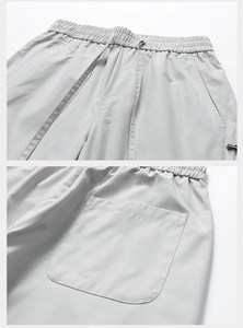 Detail view of elastic drawstring waistband and stitching on gray cargo pants