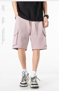 Détail du short cargo rose avec poches à rabat et taille à cordon pour hommes