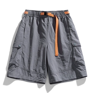 Grey tactical cargo shorts with orange belt and large utility pockets on white background