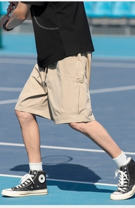 Detail of cargo shorts showing side flap pocket and drawstring waist in khaki