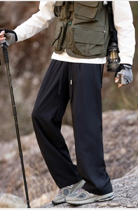 Close-up of black hiking pants featuring elastic waist and functional drawstring details