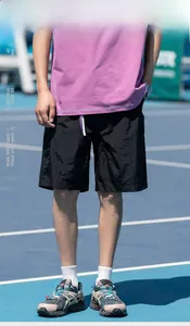 Dettaglio di t-shirt viola e pantaloncini sportivi in nylon nero su un campo da tennis