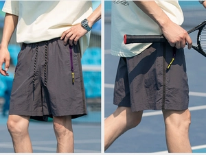 Close-up of elastic waistband and vertical zip pocket with contrast details on cargo shorts